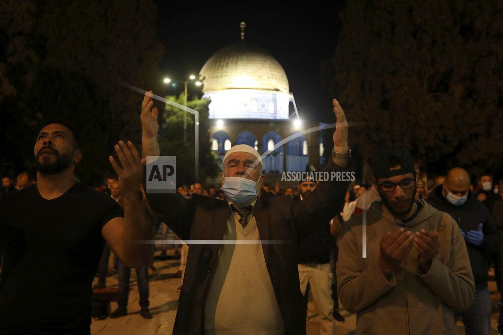Muslim men pray next to the Dome of the Rock Mosque in the Al Aqsa Mosque compound in Jerusalem's old city, Sunday, May 31, 2020.The Al-Aqsa mosque in Jerusalem, the third holiest site in Islam, reopened early Sunday, following weeks of closure aimed at preventing the spread of the coronavirus. (AP Photo/Mahmoud Illean)