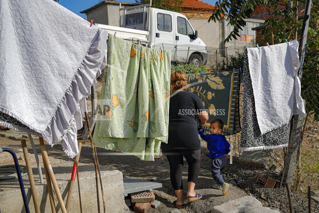 Vadim Ghirda Azime Ali Topchu, 48, a Bulgarian Roma woman, walks with one of her nephews in a village on the outskirts of Burgas, Bulgaria, Monday, Sept. 28, 2020. Human rights activists and experts say local officials in several countries with significant Roma populations have used the pandemic to unlawfully target the minority group, which is Europe's largest and has faced centuries of severe discrimination. Topchu said that the police-enforced lockdown of her village in Burgas, on Bulgaria's Black Sea Coast, made her family "really sad." (AP Photo/Vadim Ghirda)