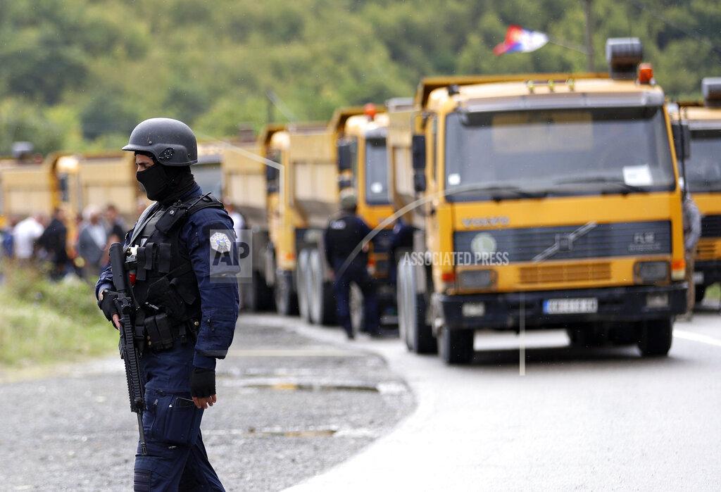 Bojan Slavkovic A Kosovo special police officer stands near trucks where Kosovo Serbs block a road near the northern Kosovo border crossing of Jarinje, Monday, Sept. 20, 2021. Tensions soared Monday at the border between Kosovo and Serbia as Kosovo deployed additional police to implement a rule to remove Serbian license plates from cars entering Kosovo, while Serbs protested the move. (AP Photo/Bojan Slavkovic)
