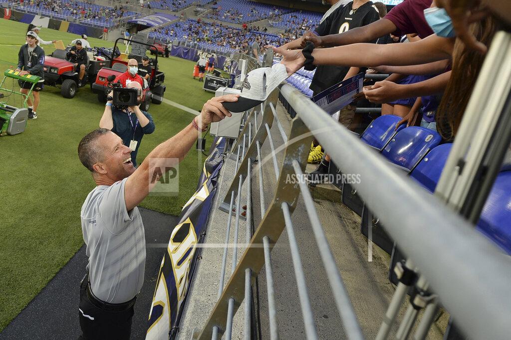 Gail Burton Baltimore Ravens coach John Harbaugh gives a fan his hat after practice at the NFL football team's training camp Saturday, July 31, 2021, in Baltimore. (AP Photo/Gail Burton)