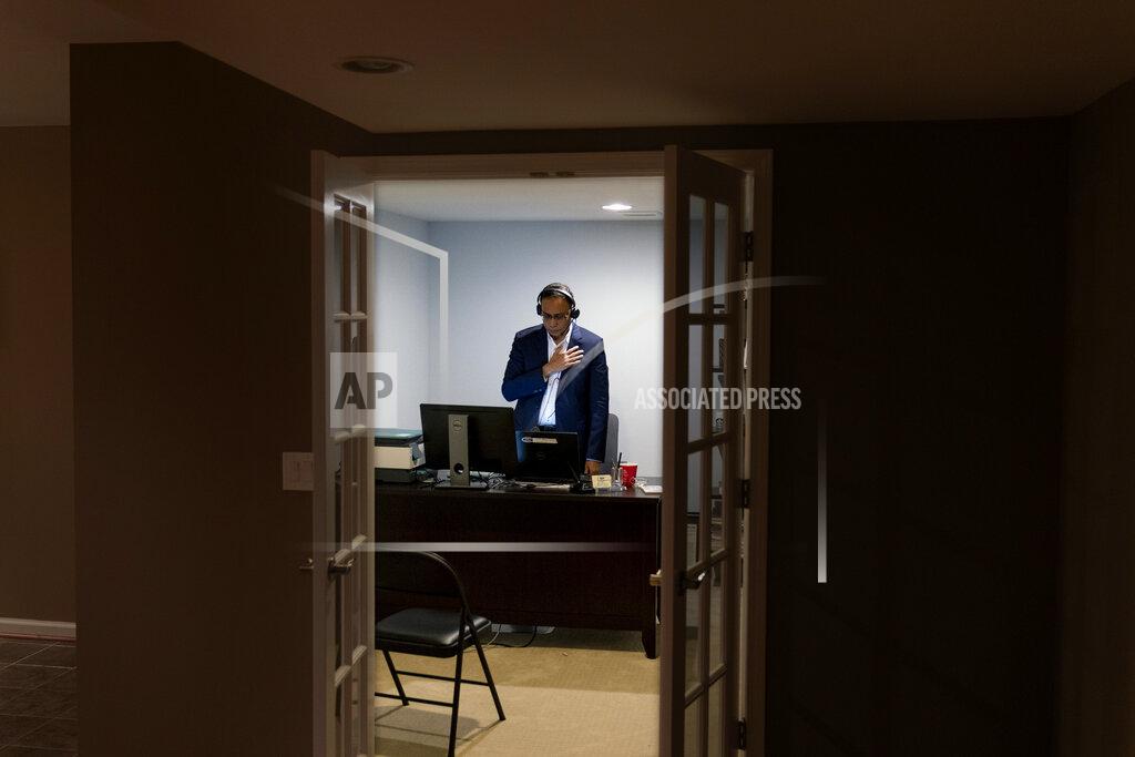 David Goldman Shahin Nazmul Hassan, founder of the Bangladeshi American Democratic Caucus in Michigan, stands for the National Anthem while conducting a virtual rally with voters and local politicians from his home in Sterling Heights, Mich., Thursday, Oct. 29, 2020. "Thirty years ago, when I came to this country, it was so beautiful, so warm and welcoming, so accepting. But that is not the culture anymore," he said. "What we've seen in the past four years is division, putting people down. There's no decency and respect." (AP Photo/David Goldman)