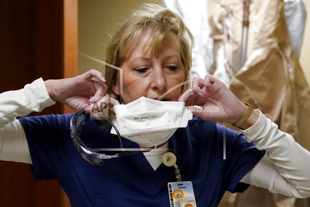 Jeff Roberson FILE - In this Nov. 24, 2020, file photo, marks are seen on the face of registered nurse Shelly Girardin as she removes a protective mask after performing rounds in a COVID-19 unit at Scotland County Hospital in Memphis, Mo. The U.S. death toll from COVID-19 has topped 500,000 — a number so staggering that a top health researchers says it is hard to imagine an American who hasn't lost a relative or doesn't know someone who died. (AP Photo/Jeff Roberson, File)