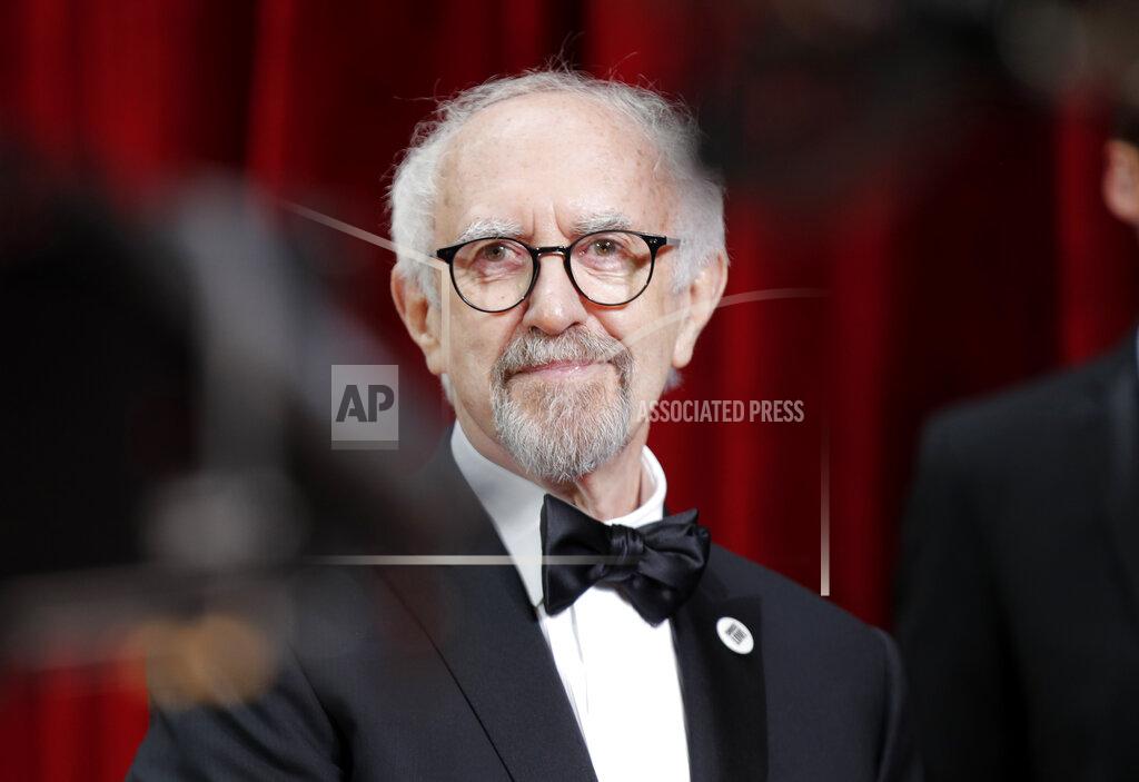 John Locher FILE - In this Sunday, Feb. 9, 2020 file photo, Jonathan Pryce arrives at the Oscars, at the Dolby Theatre in Los Angeles. Queen Elizabeth II has used her birthday honors list to celebrate the achievements of people in the limelight, as well as those at the forefront of the U.K.'s rapid rollout of coronavirus vaccines over the past few months. In the world of entertainment, actor Jonathan Pryce, who will play the queen's late husband Prince Philip in the final seasons of Netflix's royal drama The Crown, is knighted. (AP Photo/John Locher)
