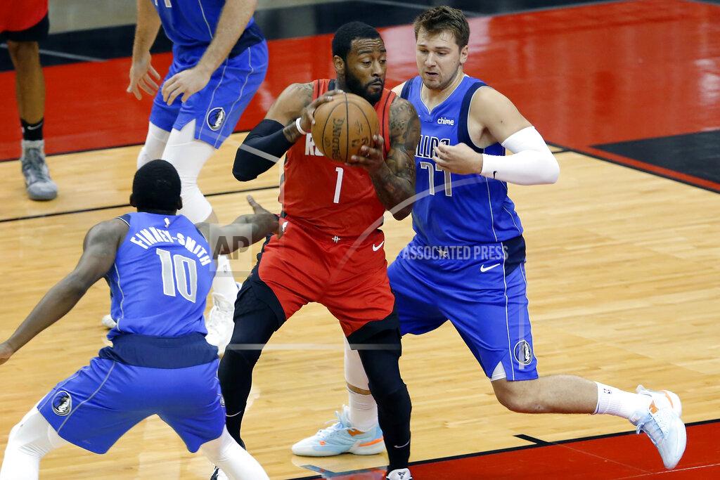 Michael Wyke Houston Rockets guard John Wall (1) drives between Dallas Mavericks forward Dorian Finney-Smith (10) and guard Luka Doncic (77) during the first half of an NBA basketball game Wednesday, April 7, 2021, in Houston. (AP Photo/Michael Wyke, Pool)