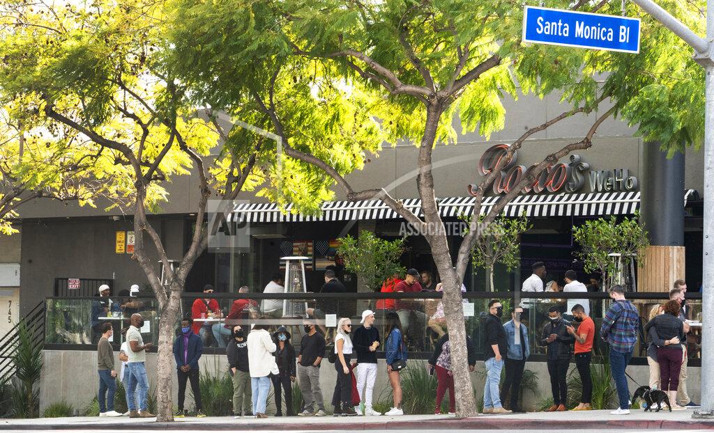 Damian Dovarganes People wait in line for an open terrace table at a restaurant on Valentine's Day during the coronavirus pandemic, Sunday, Feb. 14, 2021, in West Hollywood, Calif. (AP Photo/Damian Dovarganes)