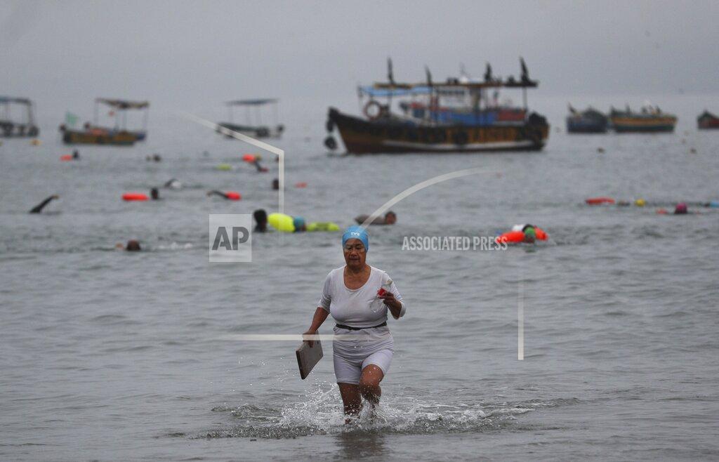 Martin Mejia An open water swimmer exits the sea on Pescadores beach, where swimming in the ocean is booming while pools are closed due to the COVID-19 pandemic in Lima, Peru, early Tuesday, April 27, 2021. One of the few sporting disciplines that have been maintained during the coronavirus pandemic is swimming, which due to the closure of the swimming pools, has moved to the open sea. (AP Photo/Martin Mejia)