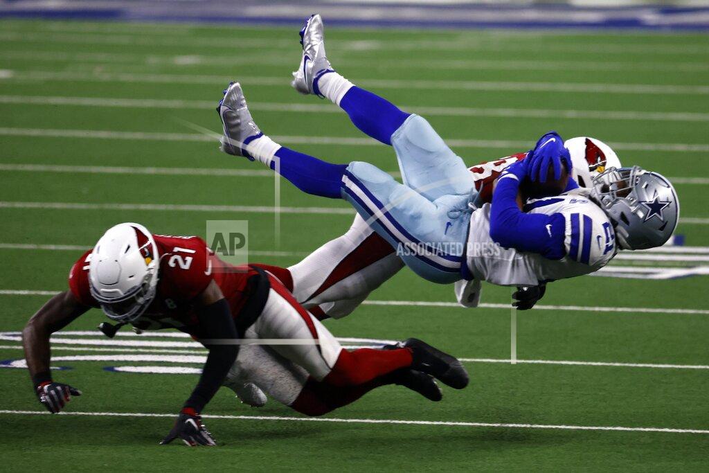 Ron Jenkins Arizona Cardinals cornerback Patrick Peterson (21) and linebacker Jordan Hicks, rear, combine to tackle Dallas Cowboys running back Ezekiel Elliott, right front, after a short gain in the second half of an NFL football game in Arlington, Texas, Monday, Oct. 19, 2020. (AP Photo/Ron Jenkins)