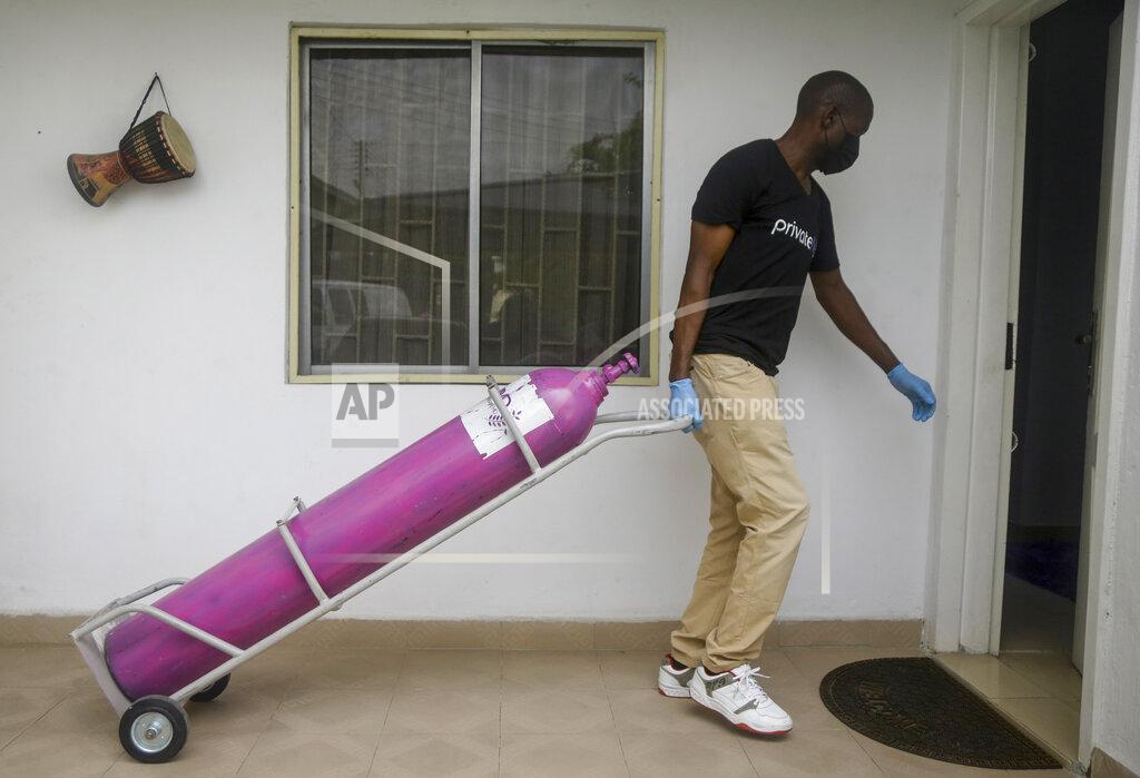 Sunday Alamba A worker from a private medical service brings oxygen bottles to aid the recovery of a COVID-19 patient, at her home in Lagos, Nigeria on Saturday, Feb. 6, 2021. A crisis over the supply of medical oxygen for coronavirus patients has struck in Africa and Latin America, where warnings went unheeded at the start of the pandemic and doctors say the shortage has led to unnecessary deaths. (AP Photo/Sunday Alamba)