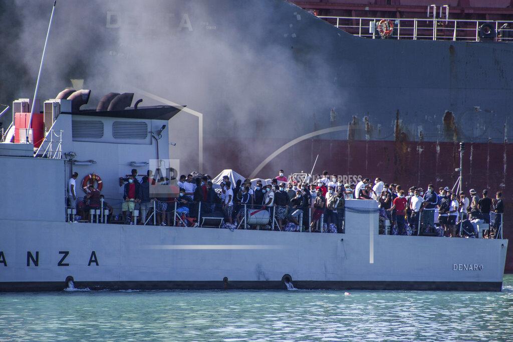 Fabio Peonia Migrants arrive in Porto Empedocle, Sicily, aboard two military ships after being transferred from the island of Lampedusa, where a number of small boat carrying migrants arrived in the last days, Monday, July 27, 2020. (Fabio Peonia/LaPresse via AP)
