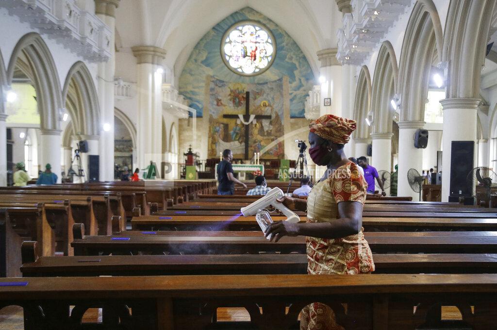 Sunday Alamba A church usher sprays disinfectant on pews to curb the spread of the coronavirus before a Sunday mass at the Holy Cross Cathedral in Lagos, Nigeria Sunday, Aug. 30, 2020. The COVID-19 pandemic is testing the patience of some religious leaders across Africa who worry they will lose followers, and funding, as restrictions on gatherings continue. (AP Photo/Sunday Alamba)