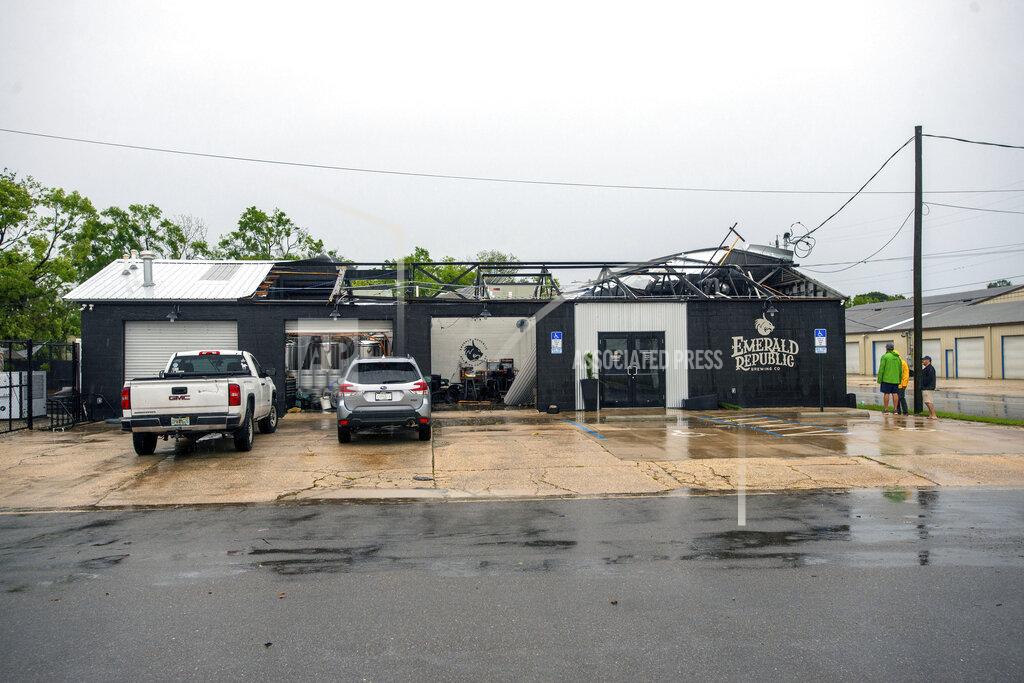 John Blackie Employees assess the damage after the storm that came through Pensacola, Fla., and blew the roof off of Emerald Republic Brewing on Saturday, April 10, 2021. (John Blackie/Pensacola News Journal via AP)