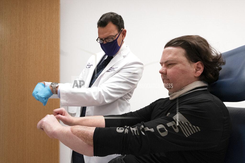 Mark Lennihan Dr. Eduardo Rodriguez has Joe DiMeo demonstrate the flexibility in his new hands, Monday, Jan. 25, 2021 at NYU Langone Health in New York. Rodriguez led a surgical team that amputated both of DiMeo’s hands, replacing them mid-forearm and connecting nerves, blood vessels and 21 tendons with hair-thin sutures. (AP Photo/Mark Lennihan)