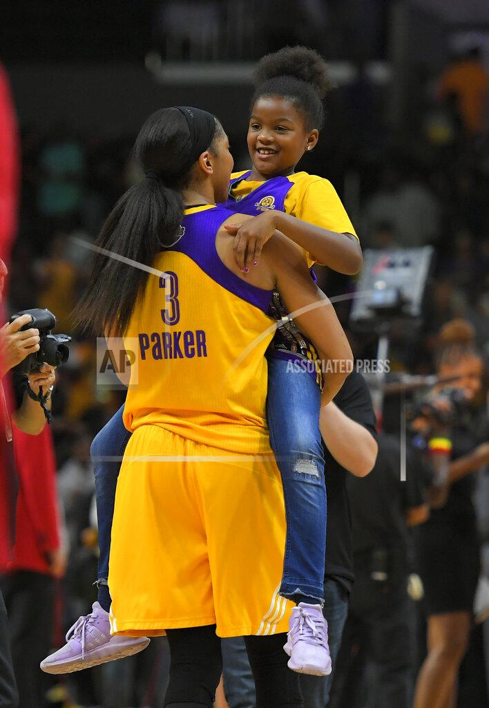 Mark J. Terrill FILE- In this Sept. 29, 2017, file photo, Los Angeles Sparks forward Candace Parker holds her daughter Lailaa Nicole Williams after Game 3 of the WNBA basketball finals against the Minnesota Lynx in Los Angeles. The Sparks won 75-64. Parker and her 11-year-old daughter are braving the start of an unprecedented WNBA season together in Florida. The Los Angeles Sparks All-Star knows it’s a calculated risk to stay in the coronavirus hot spot, where all 12 teams will play games in the WNBA “bubble” of Bradenton. (AP Photo/Mark J. Terrill, File)