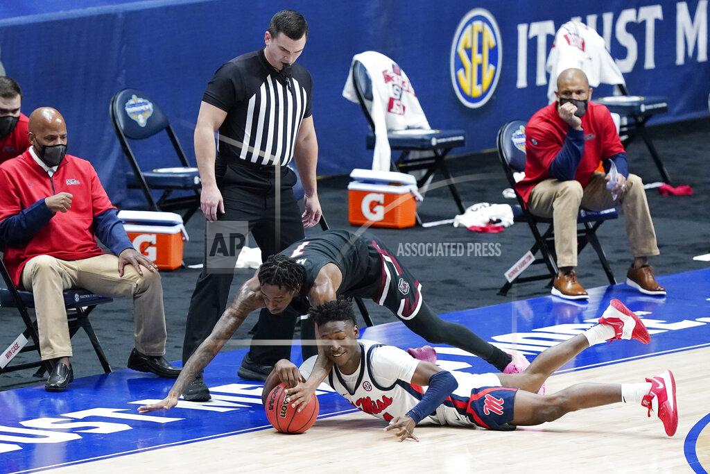 Mark Humphrey South Carolina's T.J. Moss, top, and Mississippi's Jarkel Joiner, bottom, dive for the ball in the first half of an NCAA college basketball game in the Southeastern Conference Tournament Thursday, March 11, 2021, in Nashville, Tenn. (AP Photo/Mark Humphrey)