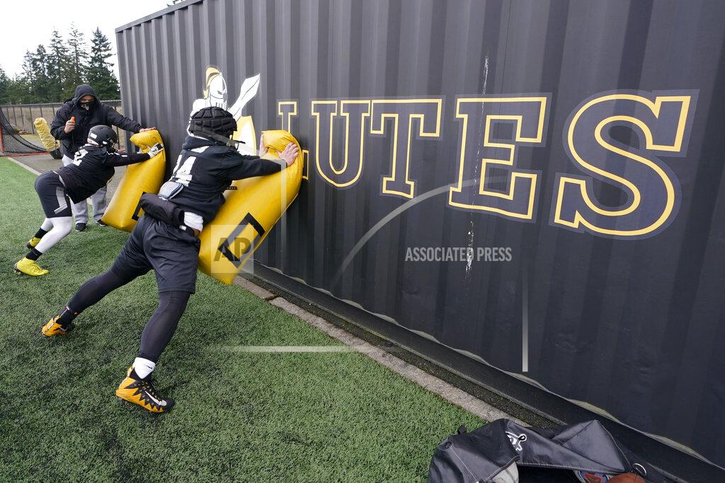 Ted S. Warren Pacific Lutheran players take part in a blocking drill against a storage container during football practice Tuesday, Feb. 2, 2021, in Tacoma, Wash. For all the attention heaped on the FBS level of college football last fall as it tried to play, it will not be the only college football during the 2020-21 sports calendar as a handful of NCAA Division III and NAIA programs begin some form of a winter/spring season Saturday, Feb. 6. (AP Photo/Ted S. Warren)