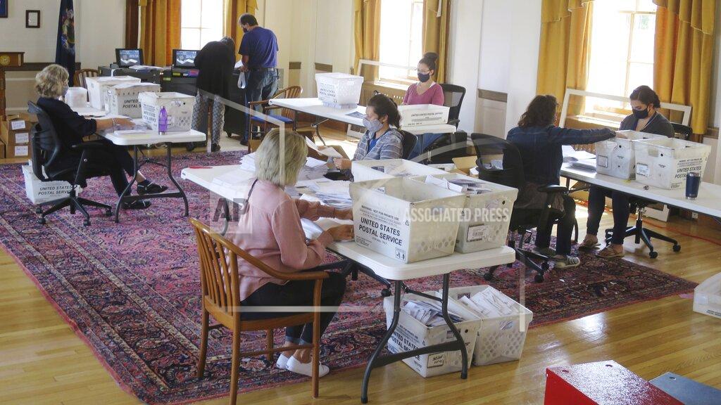 Election workers process absentee ballots for the primary elections in Portland City Hall on Friday, July 14, in Portland, Maine. Voters had been encouraged to vote via mail-in absentee ballots ahead of the election on Tuesday, July 14. (AP Photo/David Sharp)