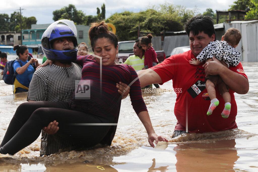 Delmer Martinez FILE - In this Nov. 5, 2020 file photo, a pregnant woman is carried out of an area flooded by water brought by Hurricane Eta in Planeta, Honduras. Thousands of homes were damaged and the infamous gang violence has not relented in Honduras, where some residents said gangs were charging a tax to boats trying to rescue people from flooded neighborhoods. (AP Photo/Delmer Martinez, File)