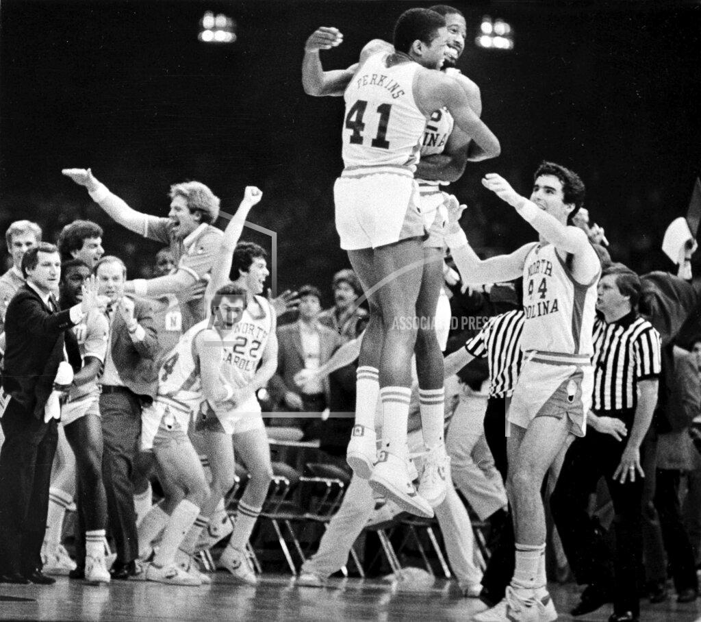 Ellis Lucia FILE - In this March 29, 1982, file photo, Sam Perkins (41) and James Worthy of North Carolina jump in the air after they defeated Georgetown 63-62 to win the NCAA Final Four college basketball championship at the Superdome in New Orleans. At far left gesturing is coach Dean Smith. (Ellis Lucia/The Times-Picayune/The New Orleans Advocate, File)