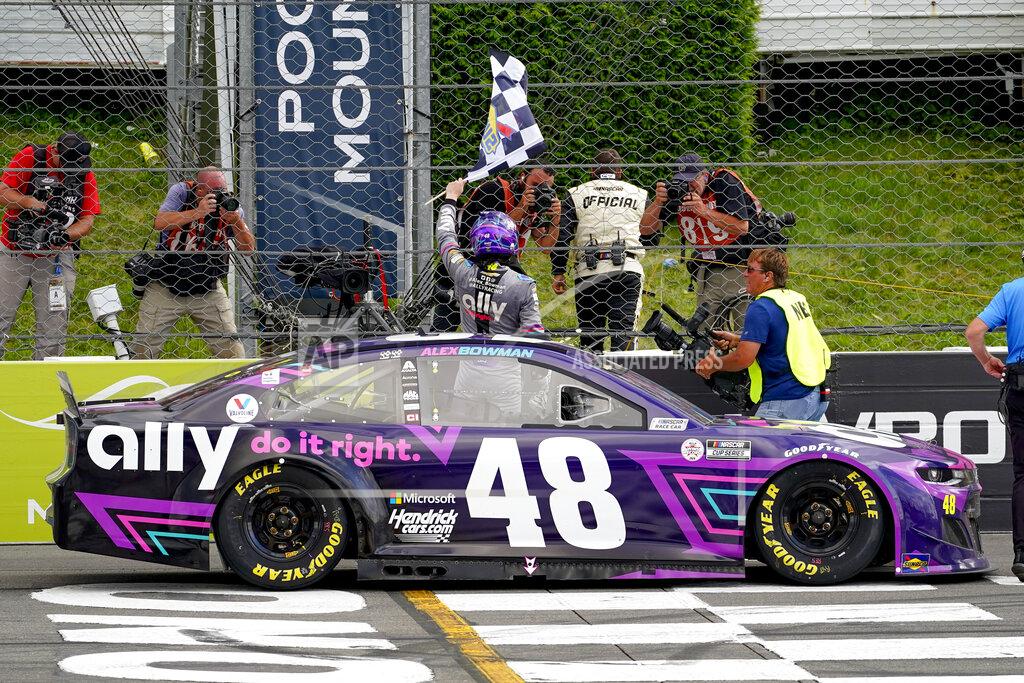 Matt Slocum Alex Bowman driver of car 48, waves the checker flag in celebration of his win after passing Kyle Larson on the last lap of the NASCAR Cup Series auto race at Pocono Raceway, Saturday, June 26, 2021, in Long Pond, Pa. (AP Photo/Matt Slocum)