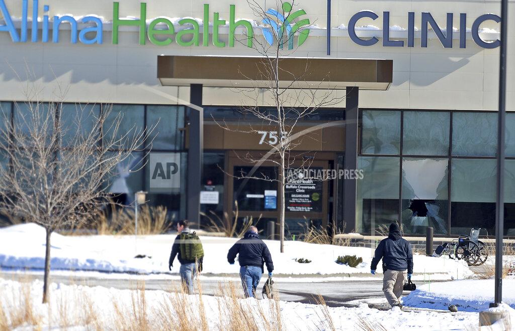 Law enforcement personnel walk toward the Allina Health clinic, Tuesday, Feb. 9, 2021, in Buffalo, Minn. Authorities say multiple people were shot at the Minnesota health clinic on Tuesday and someone was taken into custody afterward. (David Joles/Star Tribune via AP)