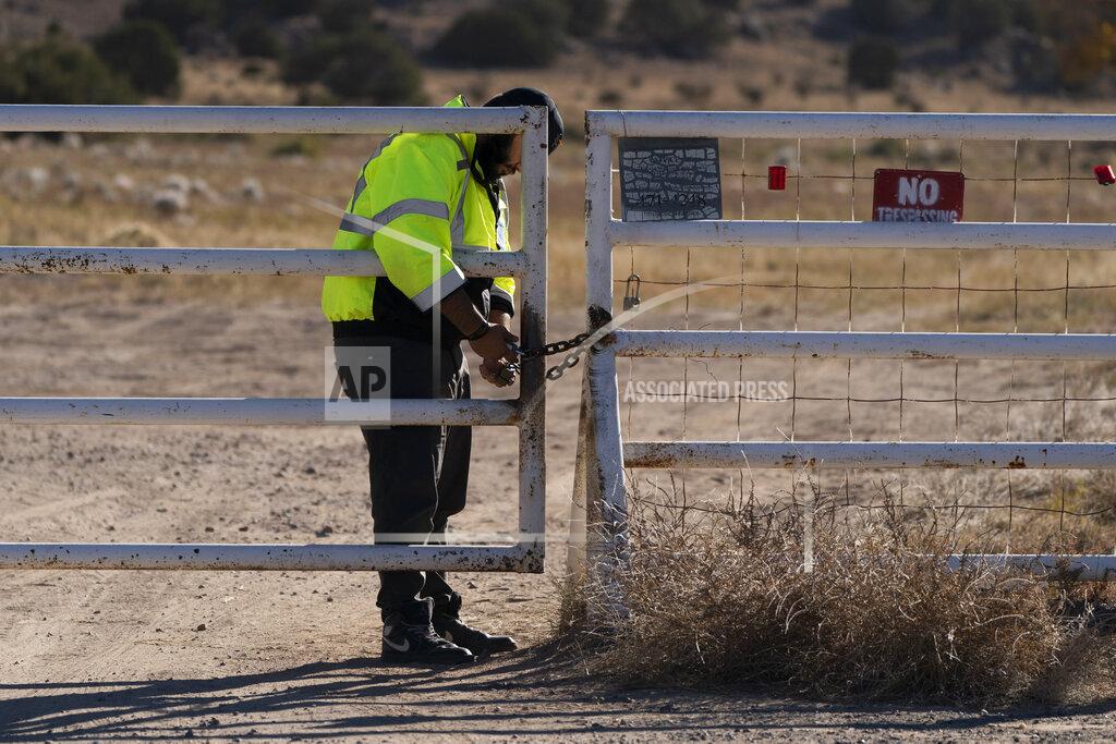 Jae C. Hong A security guard manning the entrance to the Bonanza Creek Ranch film set locks the gate after turning away workers who came to pick up equipment in Santa Fe, N.M., Monday, Oct. 25, 2021. A camera operator told authorities that Alec Baldwin had been careful with weapons on the set of the film "Rust." Baldwin shot and killed a cinematographer with a gun he'd been told was safe to use, court records released Sunday show. (AP Photo/Jae C. Hong)