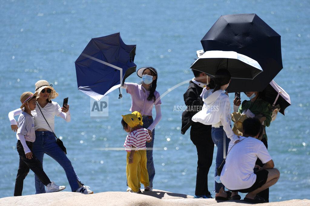 Ng Han Guan Tourists pose for photos on the waterfront at the 68-nautical-mile scenic spot, the closest point in mainland China to the island of Taiwan, in Pingtan in southeastern China's Fujian Province, Friday, Aug. 5, 2022. China conducted "precision missile strikes" Thursday in waters off Taiwan's coasts as part of military exercises that have raised tensions in the region to their highest level in decades following a visit by U.S. House Speaker Nancy Pelosi. (AP Photo/Ng Han Guan)