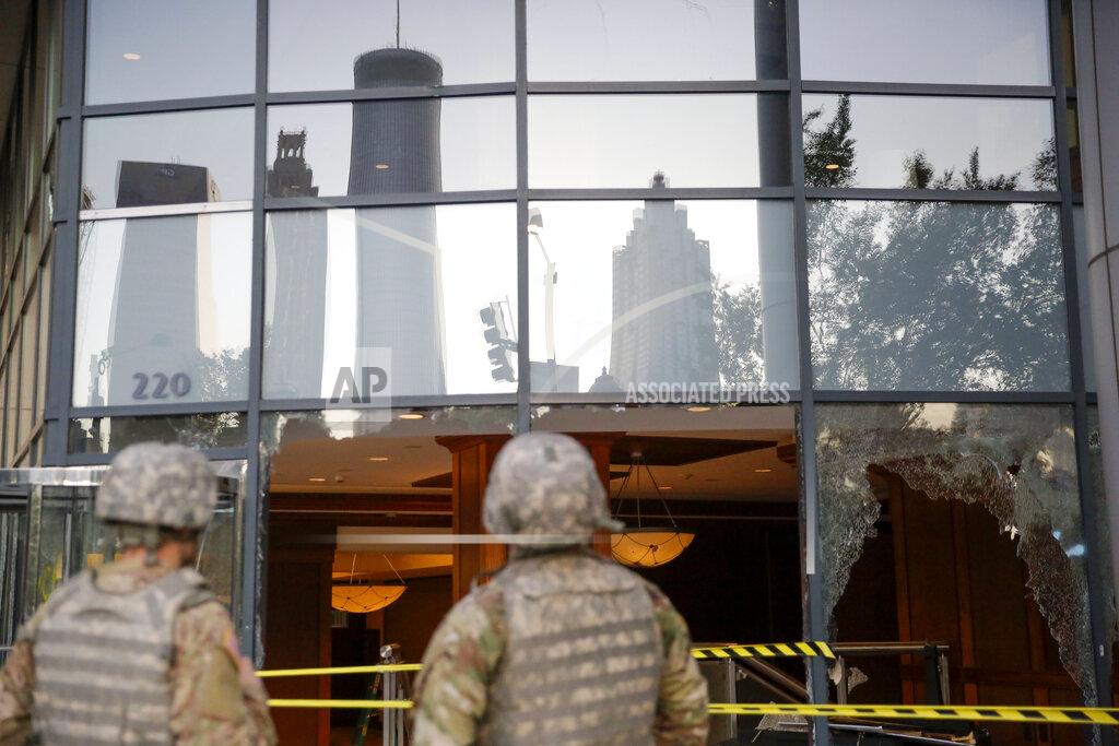 Brynn Anderson The National Guard looks at the damage done to downtown Atlanta in the aftermath of a demonstration against police violence on Saturday, May 30, 2020, in Atlanta. (AP Photo/Brynn Anderson)