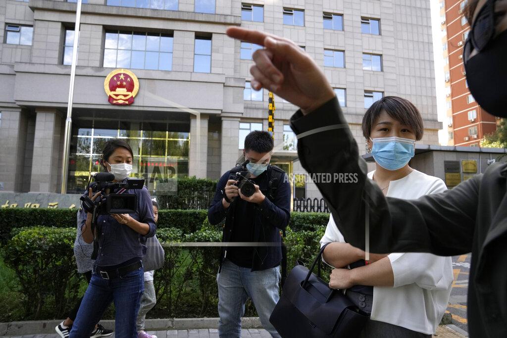 Ng Han Guan Teresa Xu, right, prepares to attend a court session at the Chaoyang People's Court in Beijing, China, Friday, Sept. 17, 2021. After almost two years, the unmarried woman suing for the right to freeze her eggs in Beijing is getting her case heard in court Friday in a rare legal challenge against the country's restrictions on unmarried women in reproductive health. (AP Photo/Ng Han Guan)
