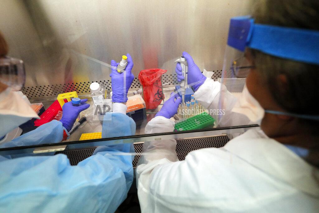 Gerald Herbert FILE - In this April 2, 2020 file photo, Cindy Morris, left, and Swarnamala Ratnayaka prepare RNA for testing for the new coronavirus at the molecular pathology lab at Tulane University School of Medicine in New Orleans. Where political divides marred early recovery efforts after Hurricane Katrina in 2005, Louisiana is showing rare political unity in the fight against the new coronavirus. (AP Photo/Gerald Herbert, File)