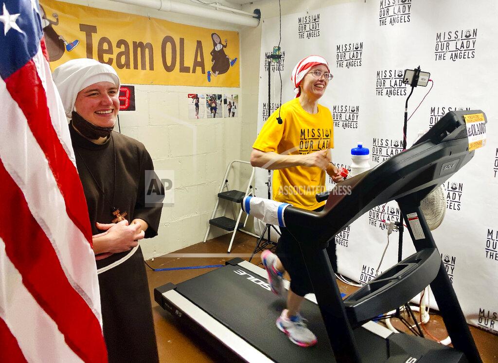 Jessie Wardarski In this Aug. 23, 2020 photo, Sister Stephanie Baliga, right, runs a marathon on a treadmill in the basement of Mission of Our Lady of the Angels church in Chicago. When the Chicago Marathon was canceled this year due to the coronavirus pandemic, Sister Baliga and her fellow nuns livestreamed the run and raised money for their community. (PJ Weiland via AP)
