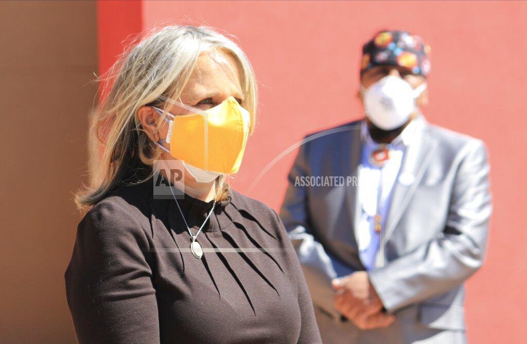 In this March 17, 2021 image, New Mexico Gov. Michelle Lujan Grisham meets with Indigenous leaders during a tour of a vaccination clinic at Kewa Pueblo, New Mexico. The New Mexico Health Department announced Friday, March 19, 2021, that the state had administered more than 1 million doses of COVID-19 vaccine. (AP Photo/Susan Montoya Bryan)