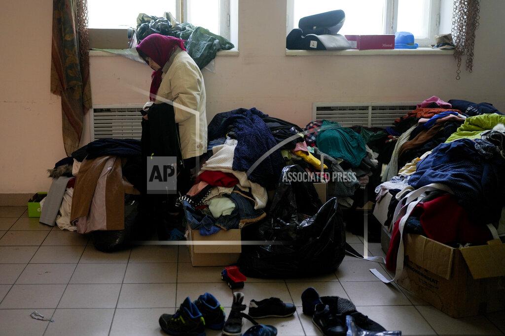 Natacha Pisarenko A woman who lost her home looks at donated cloths at a Sanatorium working as temporary place for people without a home Irpin, outskirts Kyiv, Ukraine, Thursday, May 26, 2022. (AP Photo/Natacha Pisarenko)