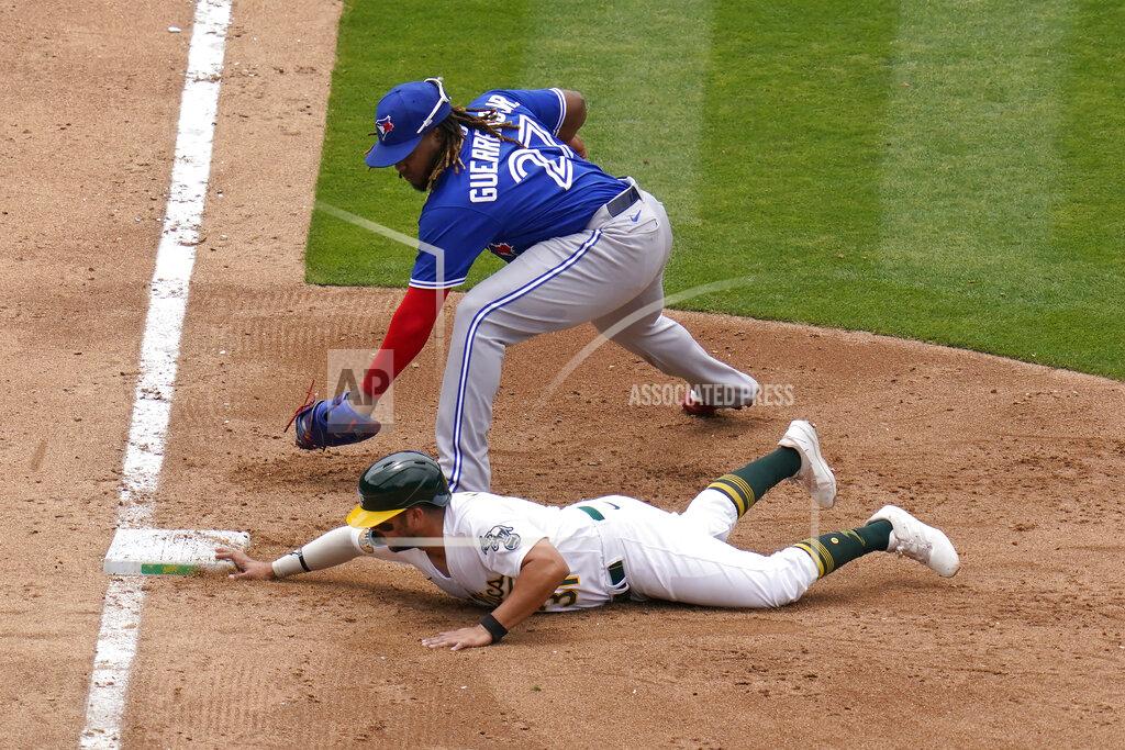 Godofredo A. Vásquez Oakland Athletics' Vimael Machin, bottom, slides safely into first base under Toronto Blue Jays first baseman Vladimir Guerrero Jr. during the fifth inning of a baseball game in Oakland, Calif., Wednesday, July 6, 2022. (AP Photo/Godofredo A. Vásquez)