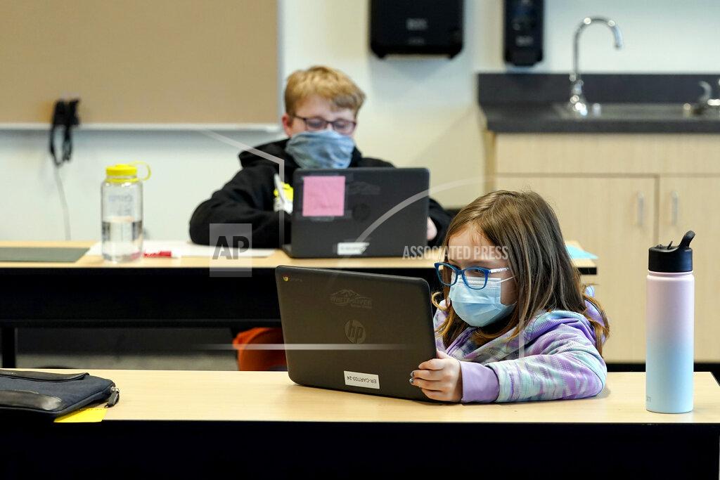 Ted S. Warren FILE - In this Feb. 2, 2021 file photo, students wear masks as they work in a fourth-grade classroom, at Elk Ridge Elementary School in Buckley, Wash. After seeing two academic years thrown off course by the pandemic, school leaders around the country are planning for the possibility of more distance learning next fall at the start of yet another school year. (AP Photo/Ted S. Warren, File)