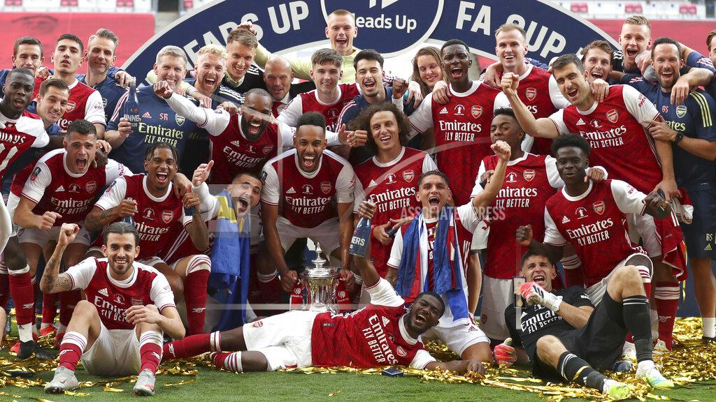 Catherine Ivill Arsenal's Pierre-Emerick Aubameyang holds the trophy celebrating with team mates players celebrate with the trophy after the FA Cup final soccer match between Arsenal and Chelsea at Wembley stadium in London, England, Saturday, Aug.1, 2020. (Catherine Ivill/Pool via AP)