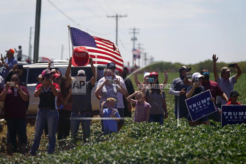 Evan Vucci President Donald Trump supporters watch as the motorcade for Trump passes by en route to the Double Eagle Energy Oil Rig, Wednesday, July 29, 2020, in Midland, Texas. (AP Photo/Evan Vucci)