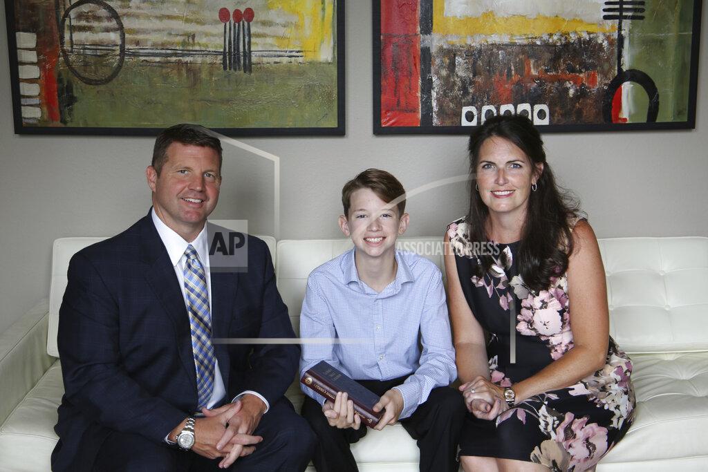 Luke George This May 2020 photo provided by the family shows Scott, left, and Dana George with their son, Braden, at their home in Houston. Eagerly anticipating the Rite of Confirmation for their 14-year-old son, Braden, Dana said the delay was “bittersweet” for her and husband. “We know by now what we plan for ourselves is not God’s plan,” she said via email. “Some see this as a disaster but my family knows we will make it through stronger in our faith.” (Luke George via AP)
