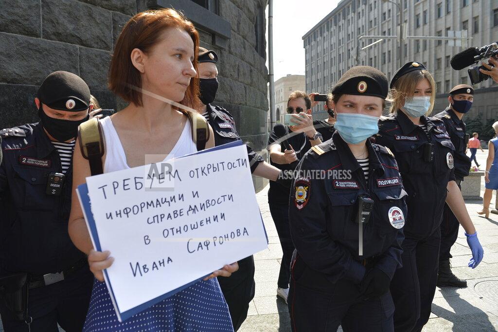Denis Kaminev Police officers detain Yelena Chernenko, a Kommersant journalist who worked with Ivan Safronov for years, with a poster reading 'We demand justice and openness in the trial of Ivan Safonov' during a picket to protest his arrest near the building of the Federal Security Service (FSB, Soviet KGB successor) in Moscow, Russia, Tuesday, July 7, 2020. Safronov, an adviser to the director of Russia's state space corporation Roscosmos, has been detained on treason charges by the nation's top security agency. (AP Photo/Denis Kaminev)