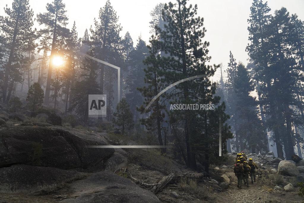 Jae C. Hong A hotshot crew from Tahoe Hotshots hikes along a trail in Meyers, Calif., Friday, Sept. 3, 2021. Fire crews took advantage of decreasing winds to battle a California wildfire near popular Lake Tahoe and were even able to allow some people back to their homes but dry weather and a weekend warming trend meant the battle was far from over. (AP Photo/Jae C. Hong)