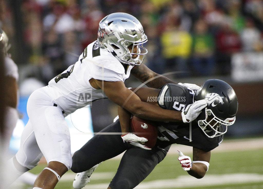 Young Kwak Oregon cornerback Deommodore Lenoir, left, tackles Washington State wide receiver Travell Harris (5) during the first half of an NCAA college football game in Pullman, Wash., Saturday, Oct. 20, 2018. (AP Photo/Young Kwak)