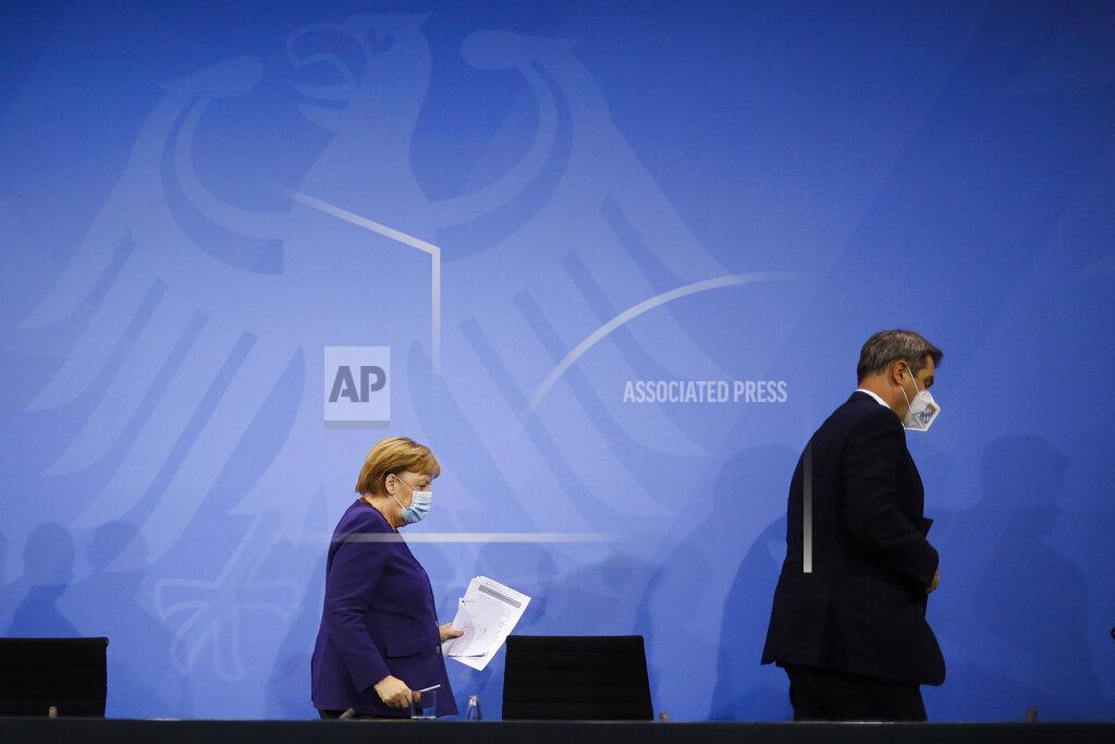 Markus Schreiber FILE - In this Wednesday, Dec. 2, 2020 file photo, German Chancellor Angela Merkel, left, and Bavarian govenor Markus Soeder, right, leave a news conference following talks of the governmnet with the federal state govenors, at the Chancellery in Berlin. The coronavirus pandemic is colliding with politics as Germany embarks on its vaccination drive and one of the most unpredictable election years in its post-World War II history. (AP Photo/Markus Schreiber, Pool, File)