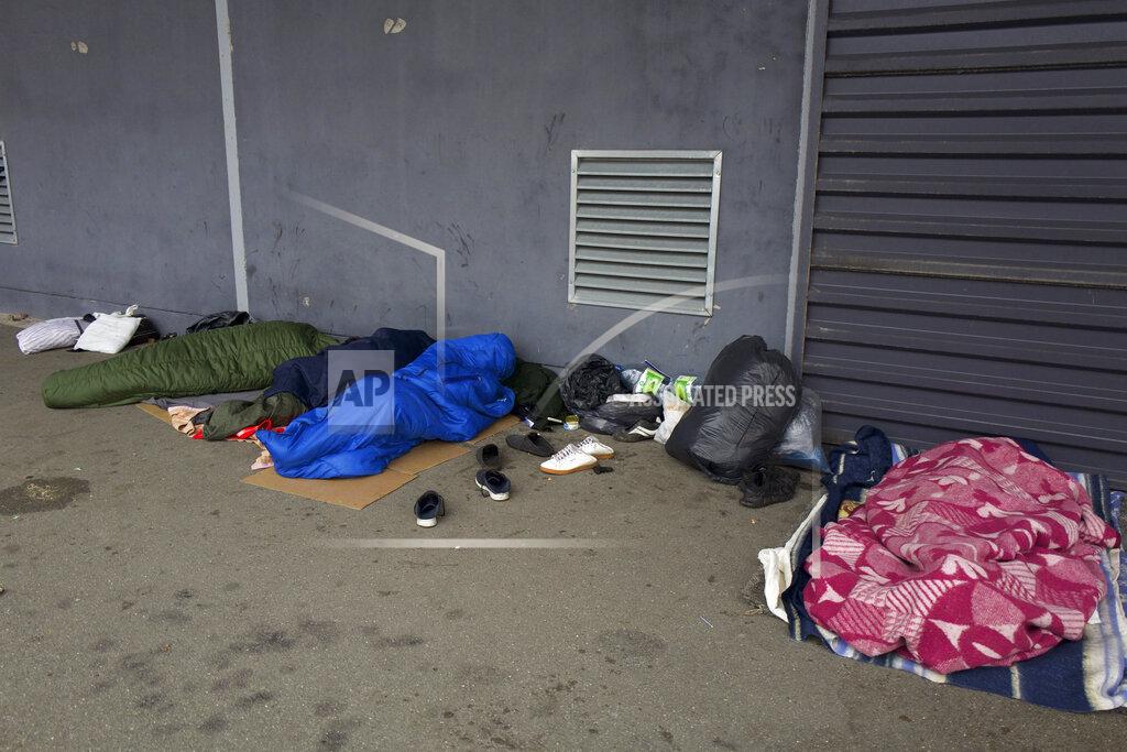 Rafael Yaghobzadeh Migrants sleep on the pavement Thursday, Nov. 25, 2021 in Calais, northern France. Children and pregnant women were among at least 27 migrants who died when their small boat sank in an attempted crossing of the English Channel, a French government official said Thursday. French Interior Minister Gerald Darmanin also announced the arrest of a fifth suspected smuggler thought to have been involved in what was the deadliest migration tragedy to date on the dangerous sea lane.(AP Photo/Rafael Yaghobzadeh)