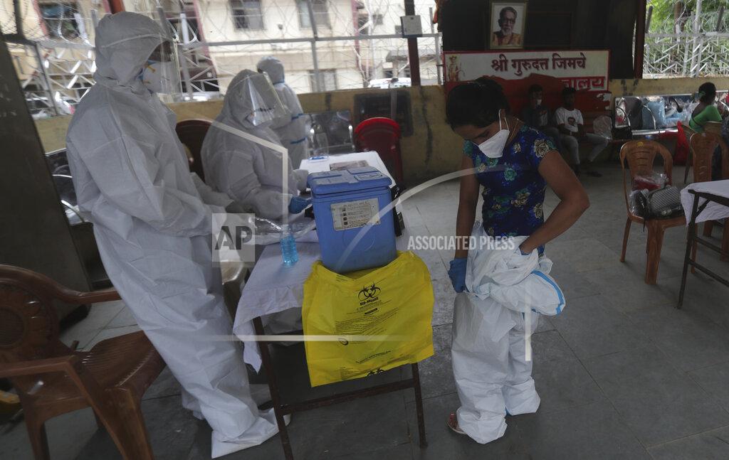 Rafiq Maqbool A health worker removes her personal protective equipment after completing screening of residents for COVID-19 symptoms in Dharavi, one of Asia's biggest slums, in Mumbai, India, Friday, June 26, 2020. India is the fourth hardest-hit country by the pandemic in the world after the U.S., Russia and Brazil. (AP Photo/Rafiq Maqbool)