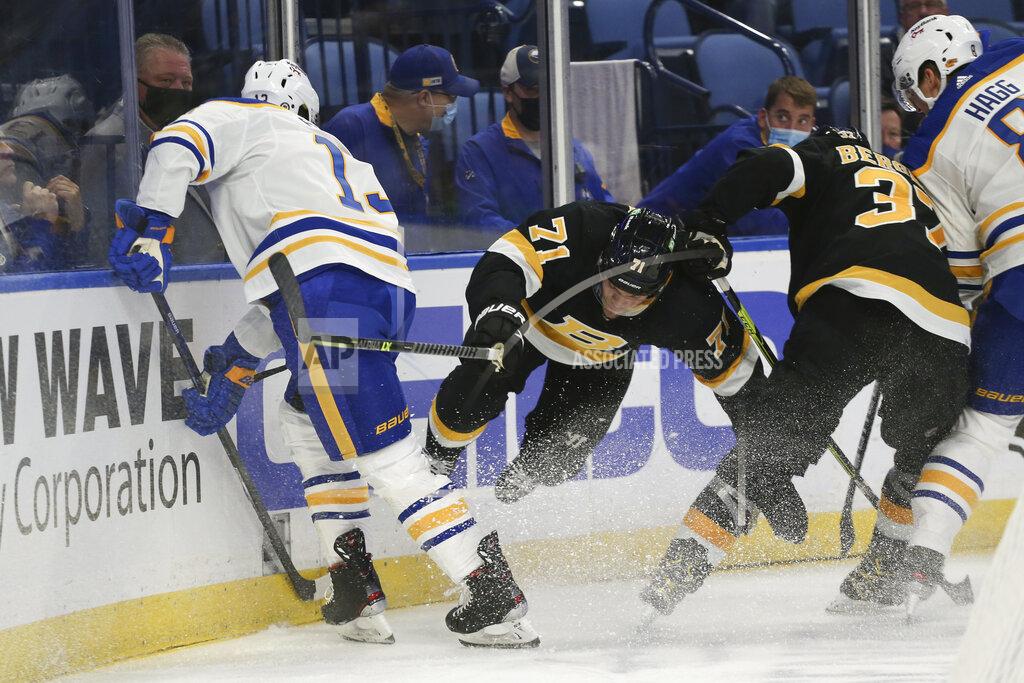 Joshua Bessex Boston Bruins left wing Taylor Hall (71) falls to the ice after checking Buffalo Sabres defenseman Mark Pysyk (13) during the second period of an NHL hockey game Friday, Oct. 22, 2021, in Buffalo, N.Y. (AP Photo/Joshua Bessex)