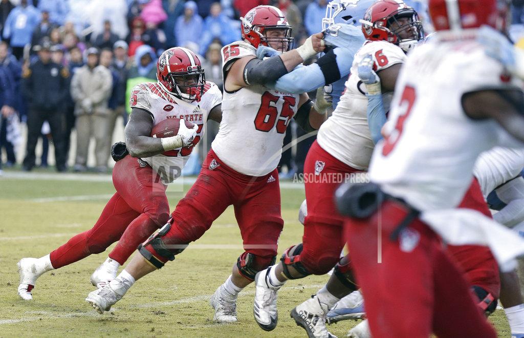 Gerry Broome North Carolina State's Reggie Gallaspy II (25) lines up behind a block by center Garrett Bradbury (65) during overtime in an NCAA college football game against North Carolina in Chapel Hill, N.C., Saturday, Nov. 24, 2018. Gallaspy scored the game-winning touchdown on the play. North Carolina State won 43-28. (AP Photo/Gerry Broome)