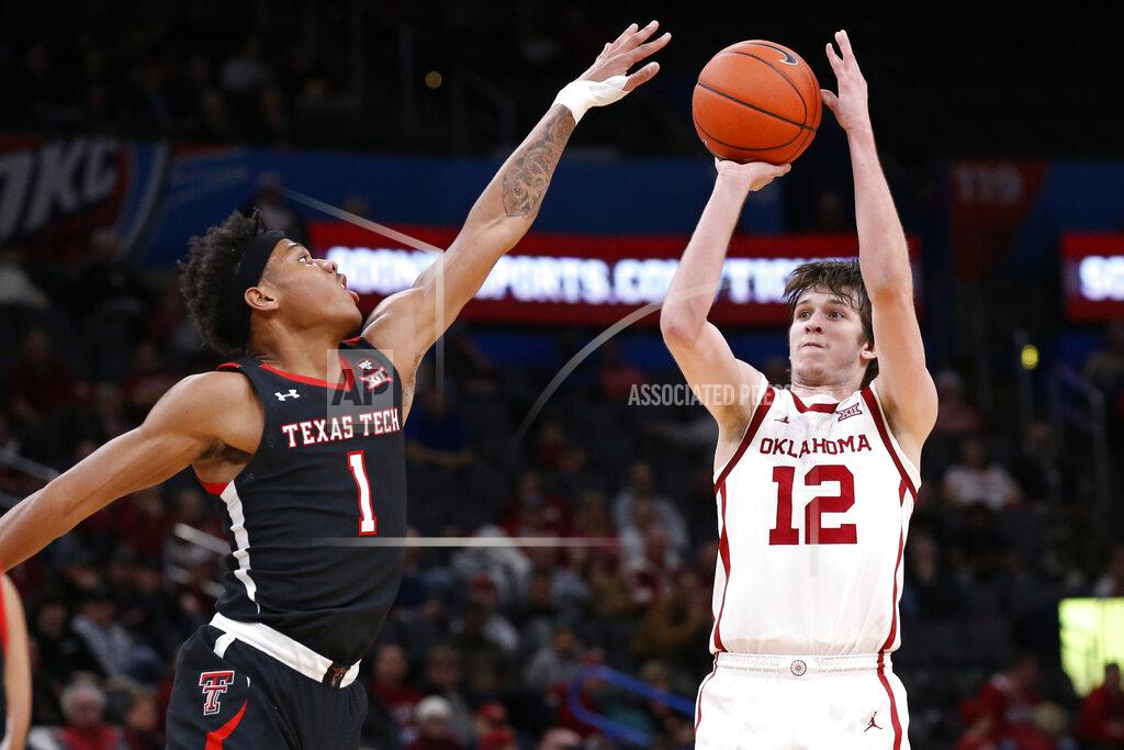 Sue Ogrocki FILE - In this Tuesday, Feb. 25, 2020 file photo, Oklahoma guard Austin Reaves (12) shoots as Texas Tech guard Terrence Shannon Jr. (1) defends in the first half of an NCAA college basketball game in Oklahoma City. The Sooners won three of their last four games last season to finish in a tie for third place in the Big 12. Plenty of talent returns, led by seniors Austin Reaves and Brady Manek. (AP Photo/Sue Ogrocki, File)