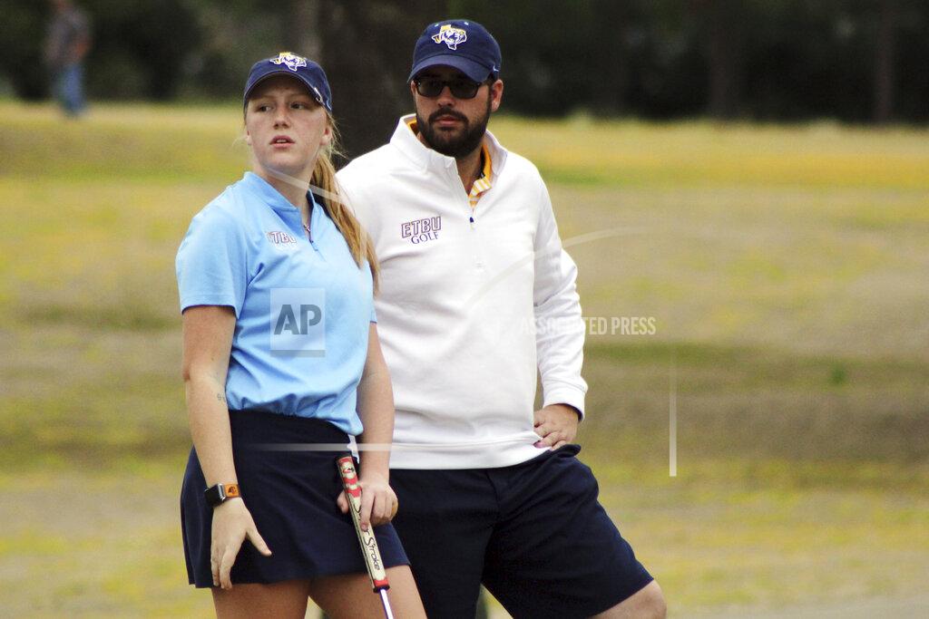 Uncredited In this image provided by East Texas Baptist University (ETBU) Athletic Communications, Tyler James, right, and golfer Elizabeth Hardy look on at the Pinecrest Invitational golf tournament on March 2, 2020, in Pinecrest Country Club, Texas, when James was a graduate assistant coach for the ETBU golf program. Nine people, including James, now University of the Southwest golf coach, and six students died in a fiery, head-on collision in West Texas on Tuesday evening, March 15, 2022, while returning home from a golf tournament, authorities said. (ETBU Athletic Communications via AP)