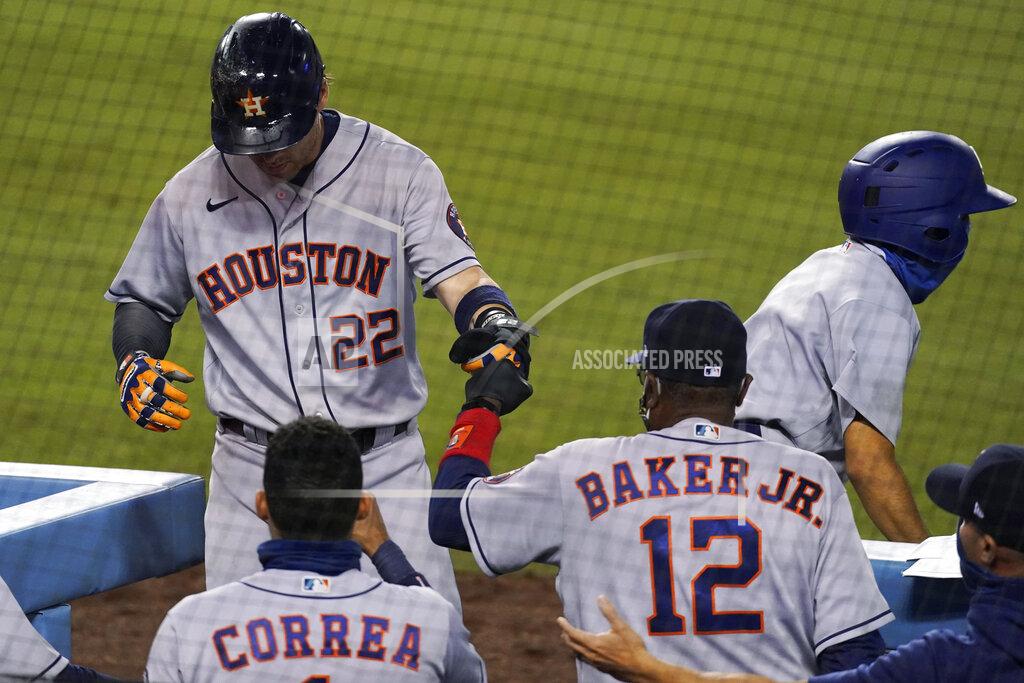 Ashley Landis Houston Astros' Josh Reddick, left, returns to the dugout after scoring the tying run during the ninth inning of the team's baseball against the Los Angeles Dodgers at Dodger Stadium on Saturday, Sept. 12, 2020, in Los Angeles. (AP Photo/Ashley Landis)