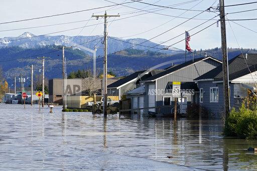 FILE - Floodwater inundates homes along a road on Nov. 17, 2021, in Sumas, Wash. Damages from flooding last week in northwest Washington's Whatcom County could reach as high as $50 million, officials said, as forecasters warn that multiple "atmospheric rivers" may drench the Pacific Northwest in coming days. (AP Photo/Elaine Thompson, File)
