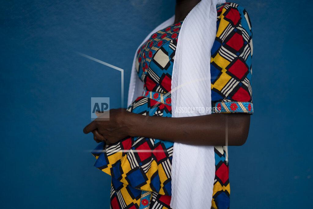Leo Correa Mariama poses for a picture in Koidu, district of Kono, Sierra Leone, Tuesday, Nov. 24, 2020. Mariama, who estimates her age at 17, had left her remote village near the border with Guinea to live with an aunt in Koidu and attend school. Then in April a 28-year-old man in their compound expressed interest in her. It took a month for Mariama to say yes over her aunt's threats to send her back to her village, where her father is struggling to feed two wives and 10 other children and her mother would be embarrassed by her return. If she has a daughter, one thing is certain, she says: “I will not give my child to anybody. I will take care of her.” (AP Photo/Leo Correa)